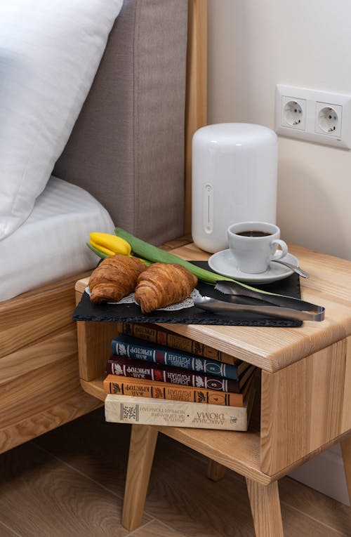 Free High angle of croissants with cup of coffee served with tulip for 8 of March on bedside with stack of books Stock Photo