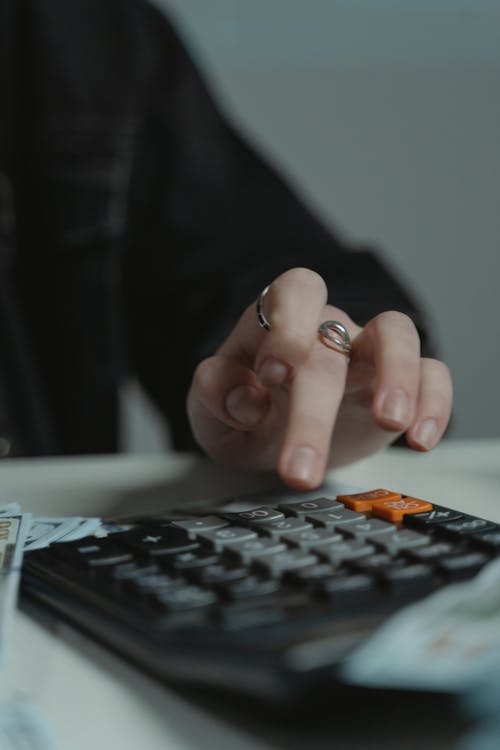 Free Person Using a Calculator on the Table Stock Photo