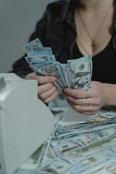 A woman counting cash with a money counter, symbolizing financial management.