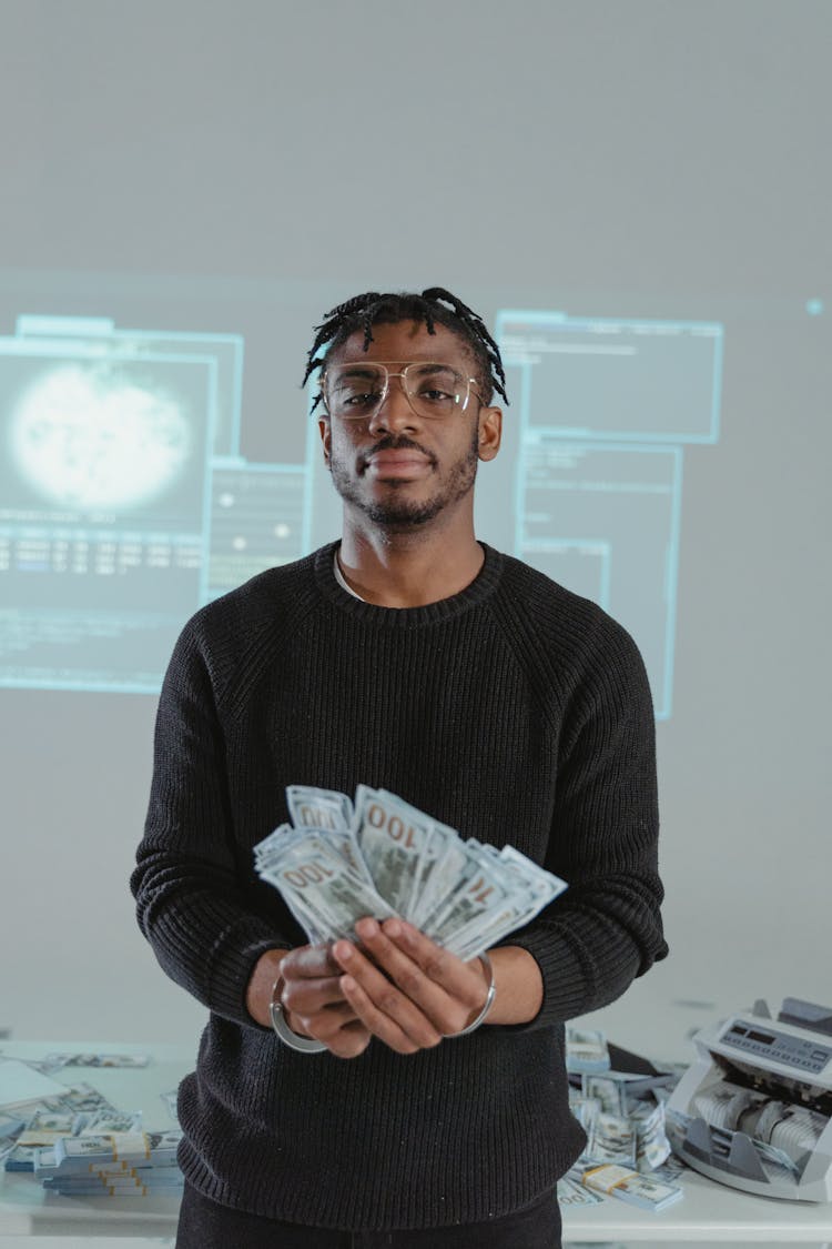 Man In Black Sweater Holding 100 Us Dollar Bill