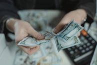 Close-Up Photo of a Person Counting Bank Notes
