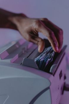 A hand operates a money counter, sorting banknotes efficiently.