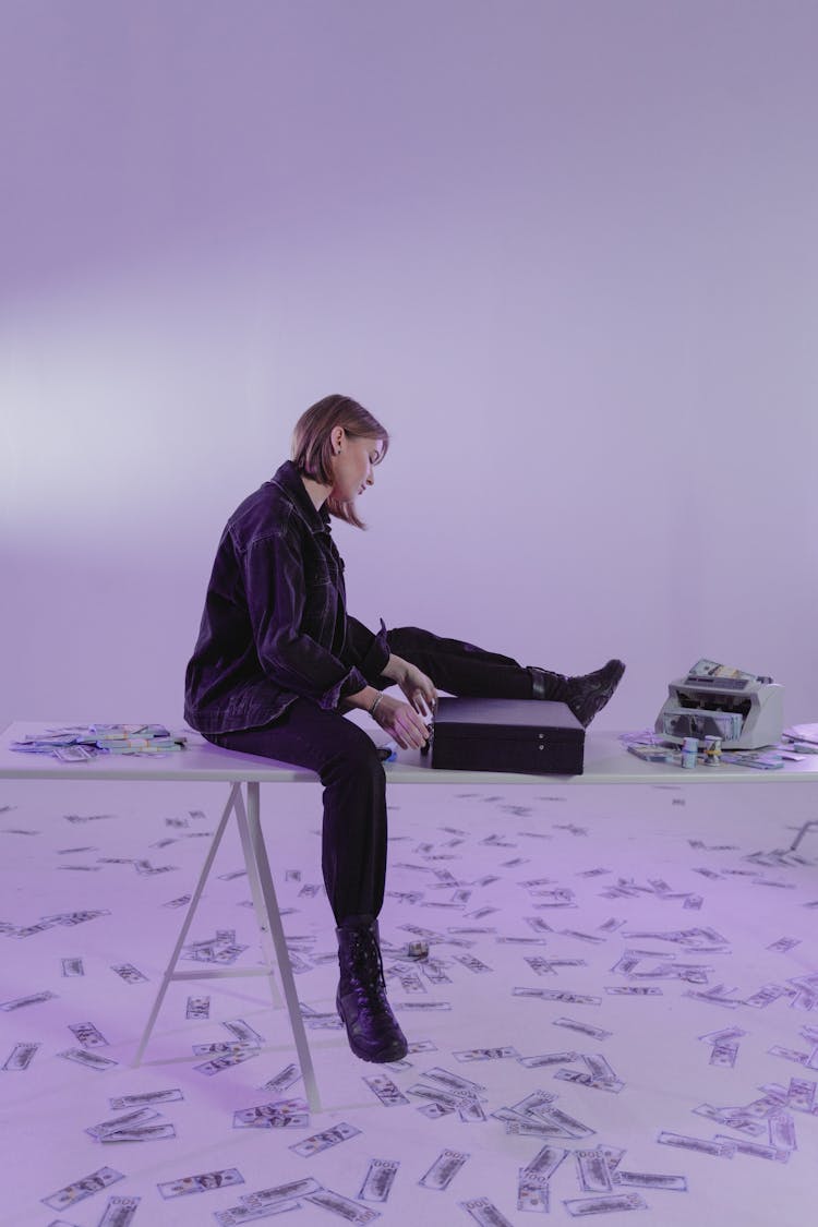 Woman In Black Jacket Sitting On Table With A Briefcase