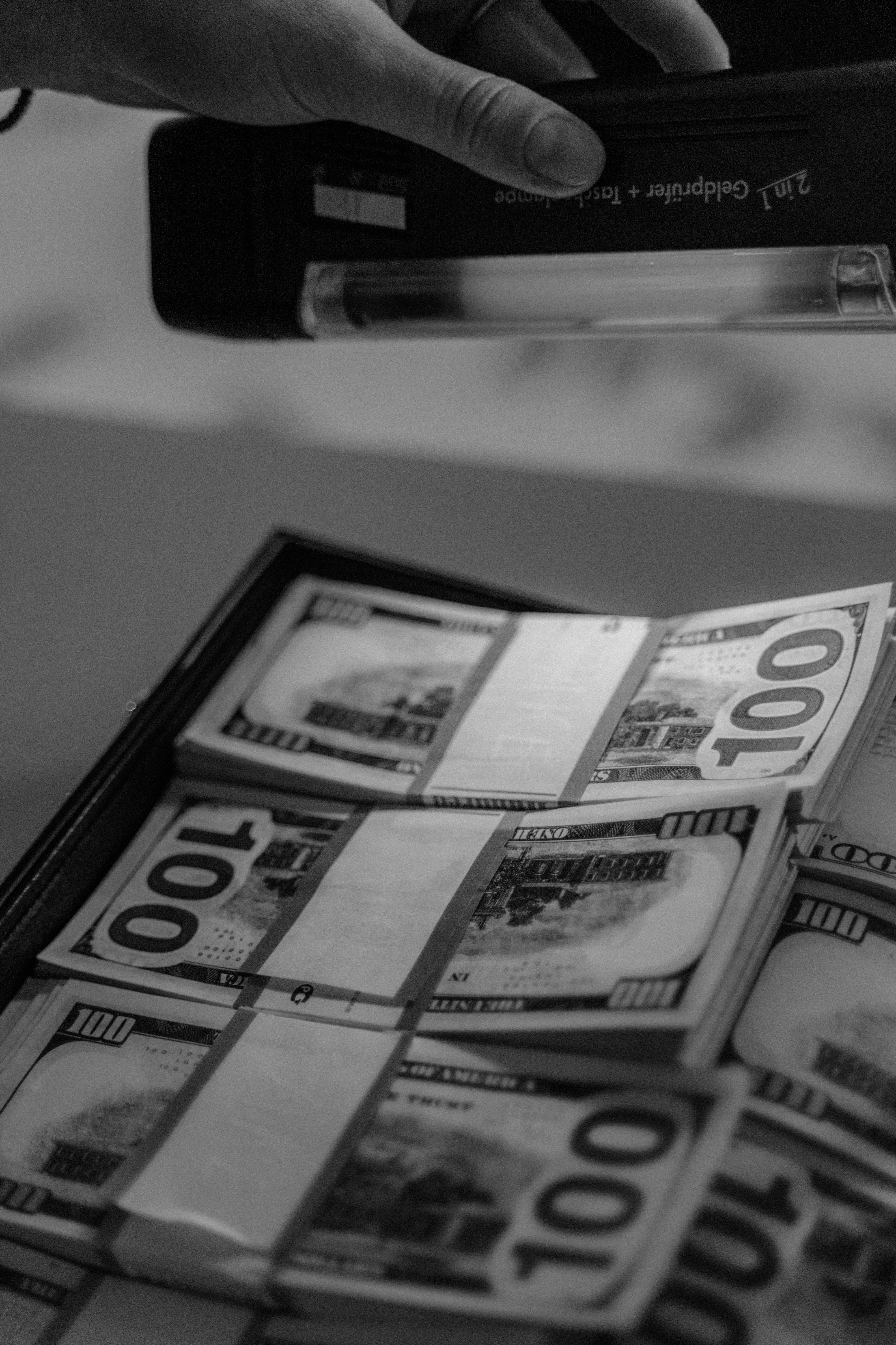 a grayscale of a person using uv light on money