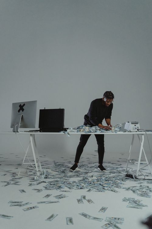 Free Businessman counting large sum of money on a desk, conveying themes of wealth and finance. Stock Photo