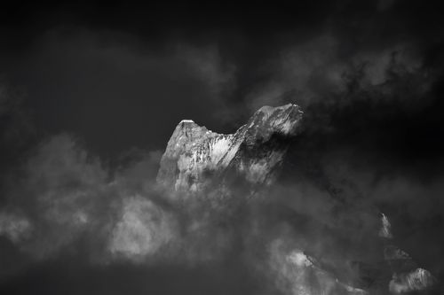Free Breathtaking view of a snow-covered Himalayan peak in Nepal shrouded in clouds at night. Stock Photo