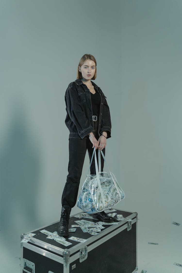 Woman Standing On Top Of Black Luggage