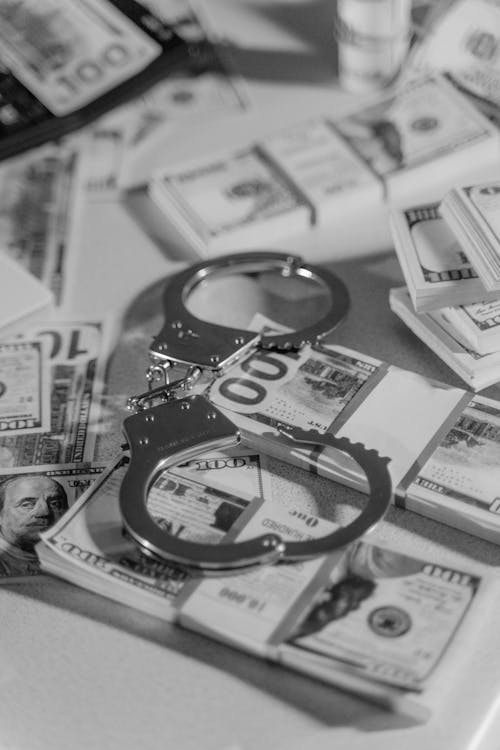 Free Silver Handcuffs on Top of Bundled Paper Money Stock Photo