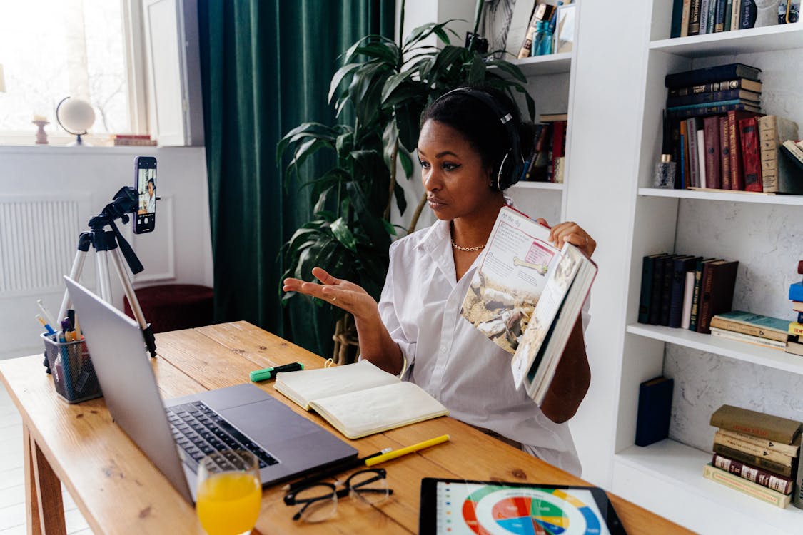 Woman Sitting in Front of Laptop Teaching Online