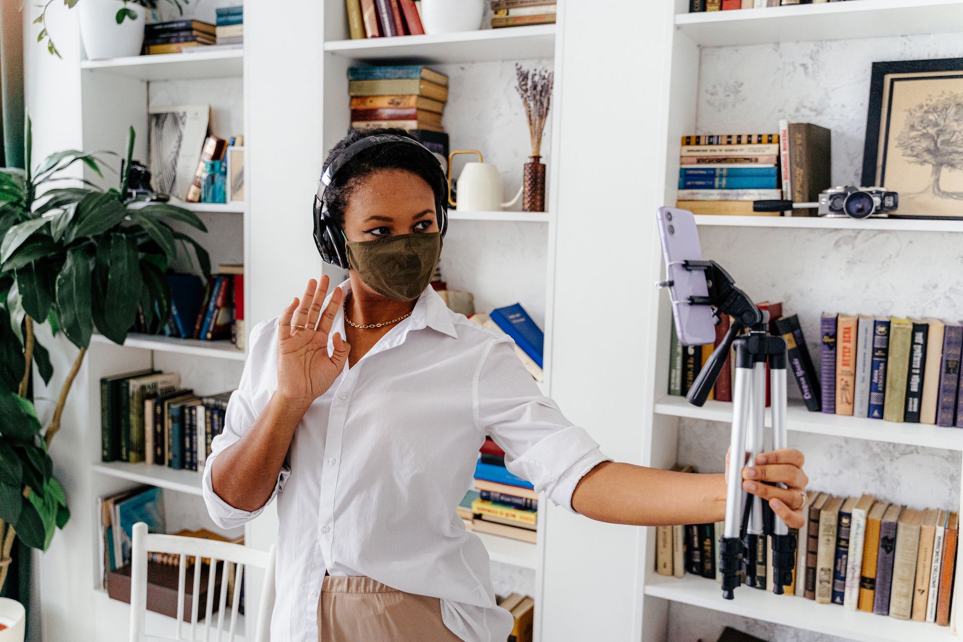 Woman with Mask Waving Hand in Front of Smartphone