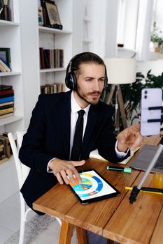 Business professional using technology for an online meeting with headphones and tablet.