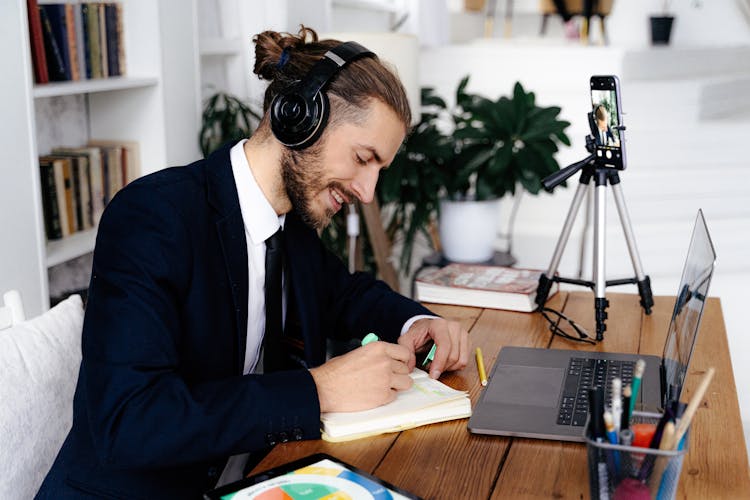 Smiling Man In Headphones Studying At Home