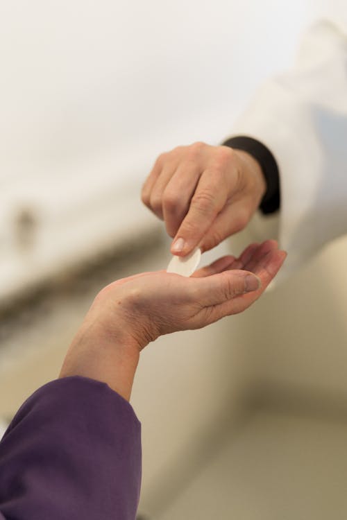 Free A Person Giving Communion Bread on Hand Stock Photo