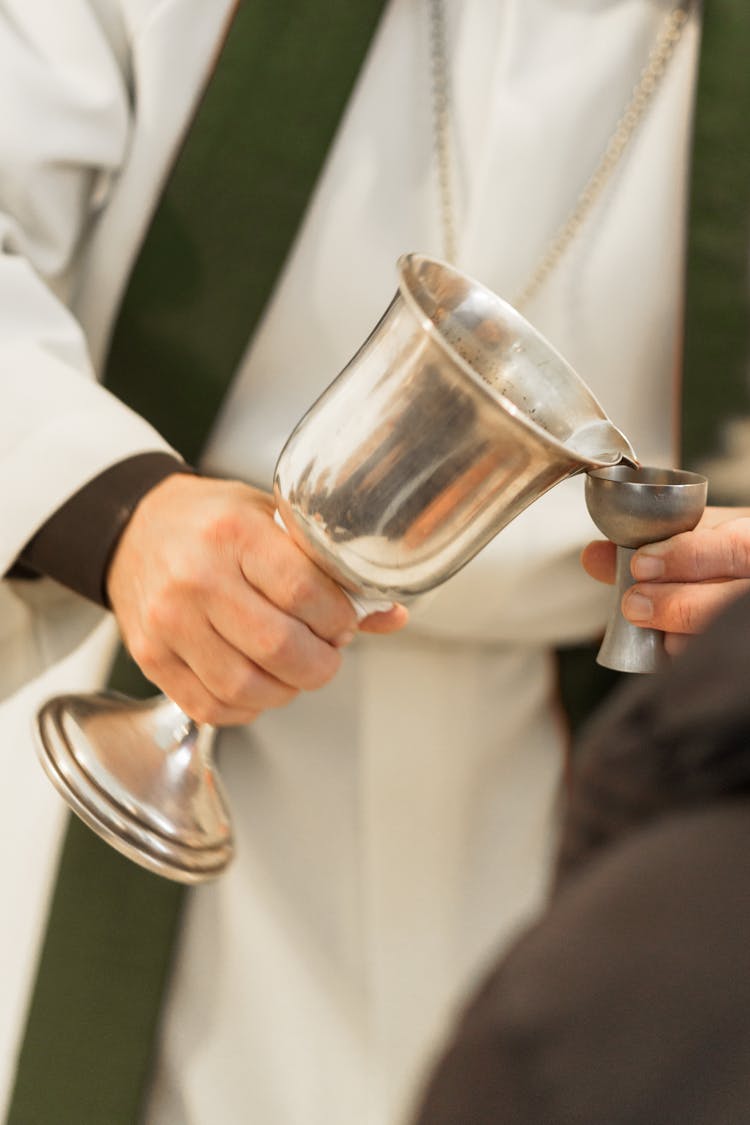 Priest Holding A Silver Chalice 