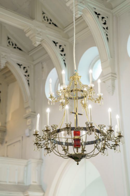 Free Beautifully detailed chandelier hanging in a historic church interior with soft lighting. Stock Photo