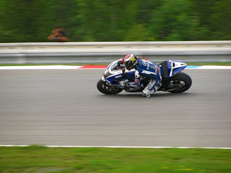 Dynamic shot of a professional motorcycle racer speeding on a track during a competition.