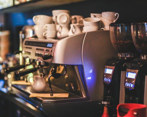 Barista pouring steamed milk into a coffee cup