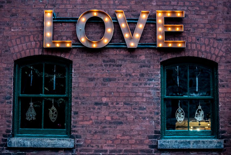 Light Letters Near Windows On Brick Wall