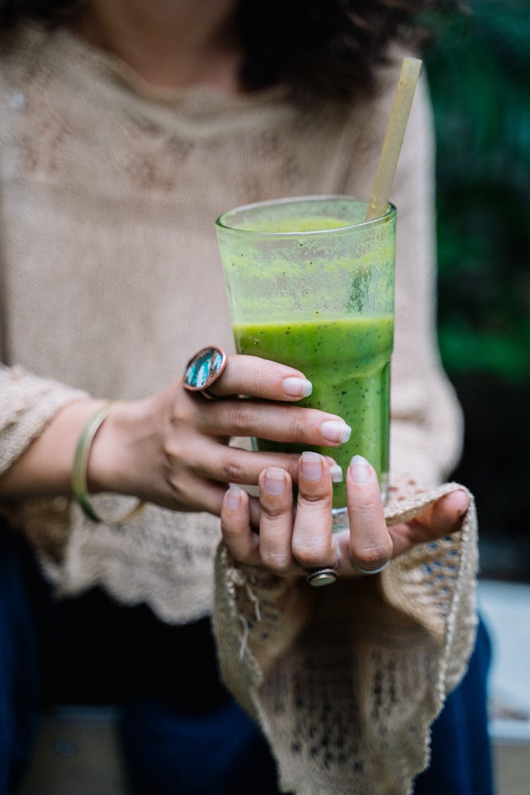 Woman Holding A Green Drink On Clear Glass 