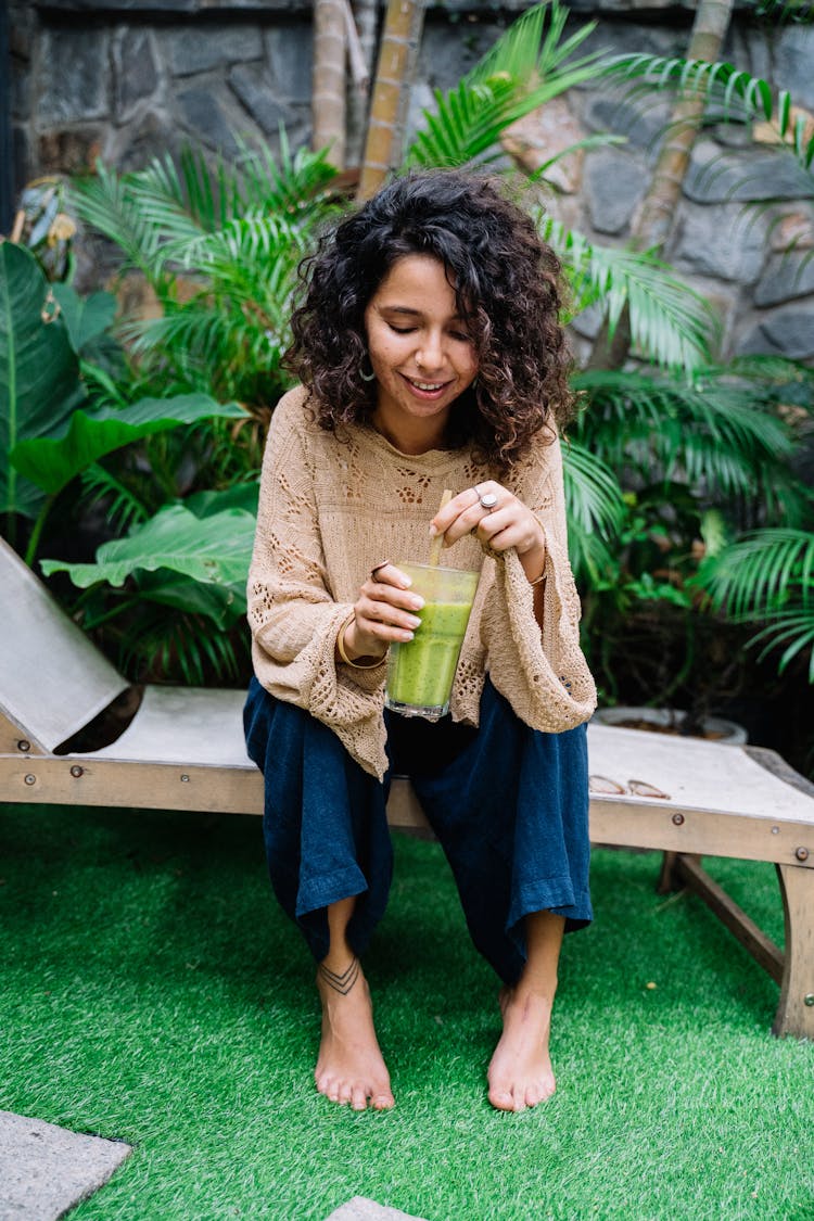 Woman With Curly Hair Drinking Green Smoothie