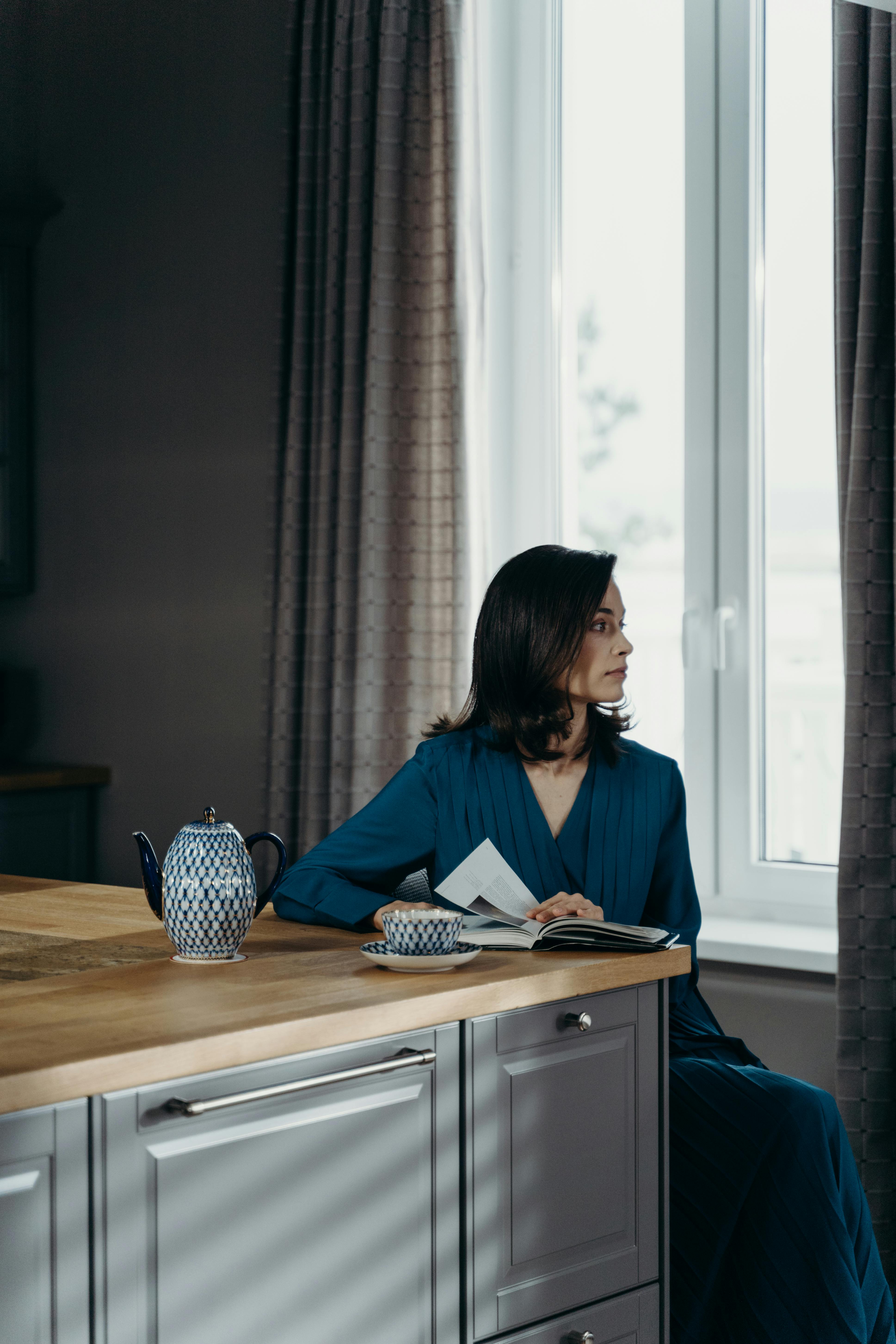 woman in blue dress reading a book