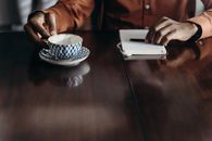 Person Holding White and Black Ceramic Teacup