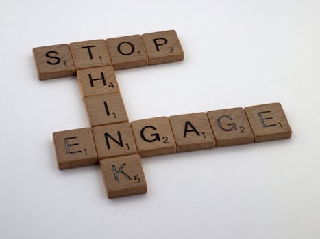 Wooden Scrabble tiles spelling 'Stop Think Engage' for strategic concepts.