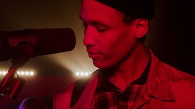 Male singer performing under red stage lighting