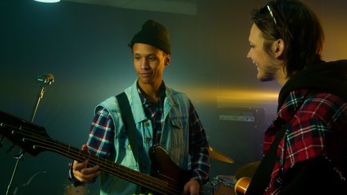 Free Two young male musicians practicing in a rehearsal studio with electric bass guitar. Stock Photo