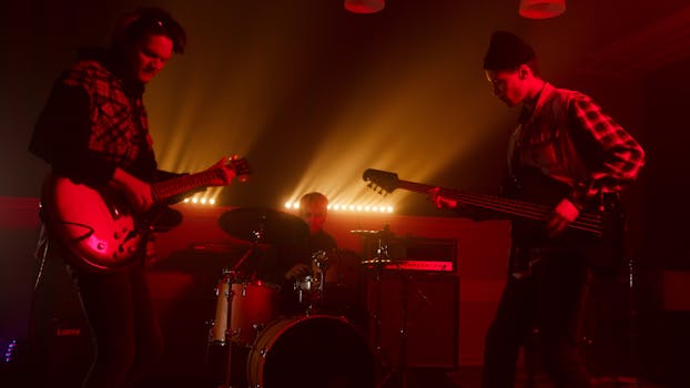 Energetic live band performance featuring electric guitars and drums under dramatic lighting.