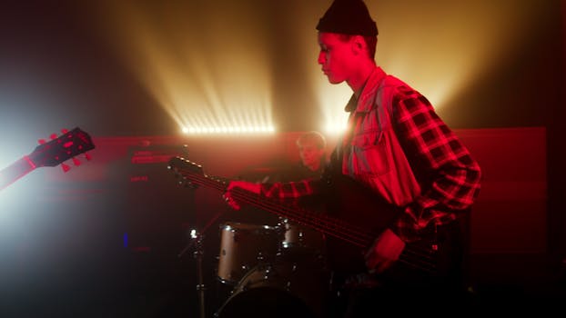 Energetic live band performance with guitarist and drummer under vibrant stage lights.