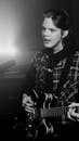 Grayscale Photo of a Man Playing a Guitar