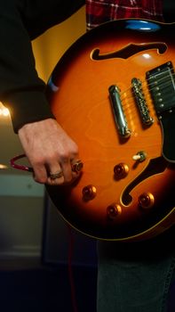Close-up of a musician adjusting controls on an electric guitar, capturing the essence of music and creativity.