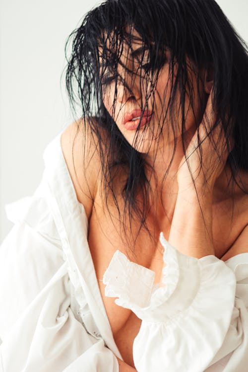 Crop seductive woman with wet hair on white background