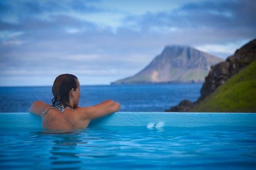 Woman in Swimming Pool Looking at Mountain