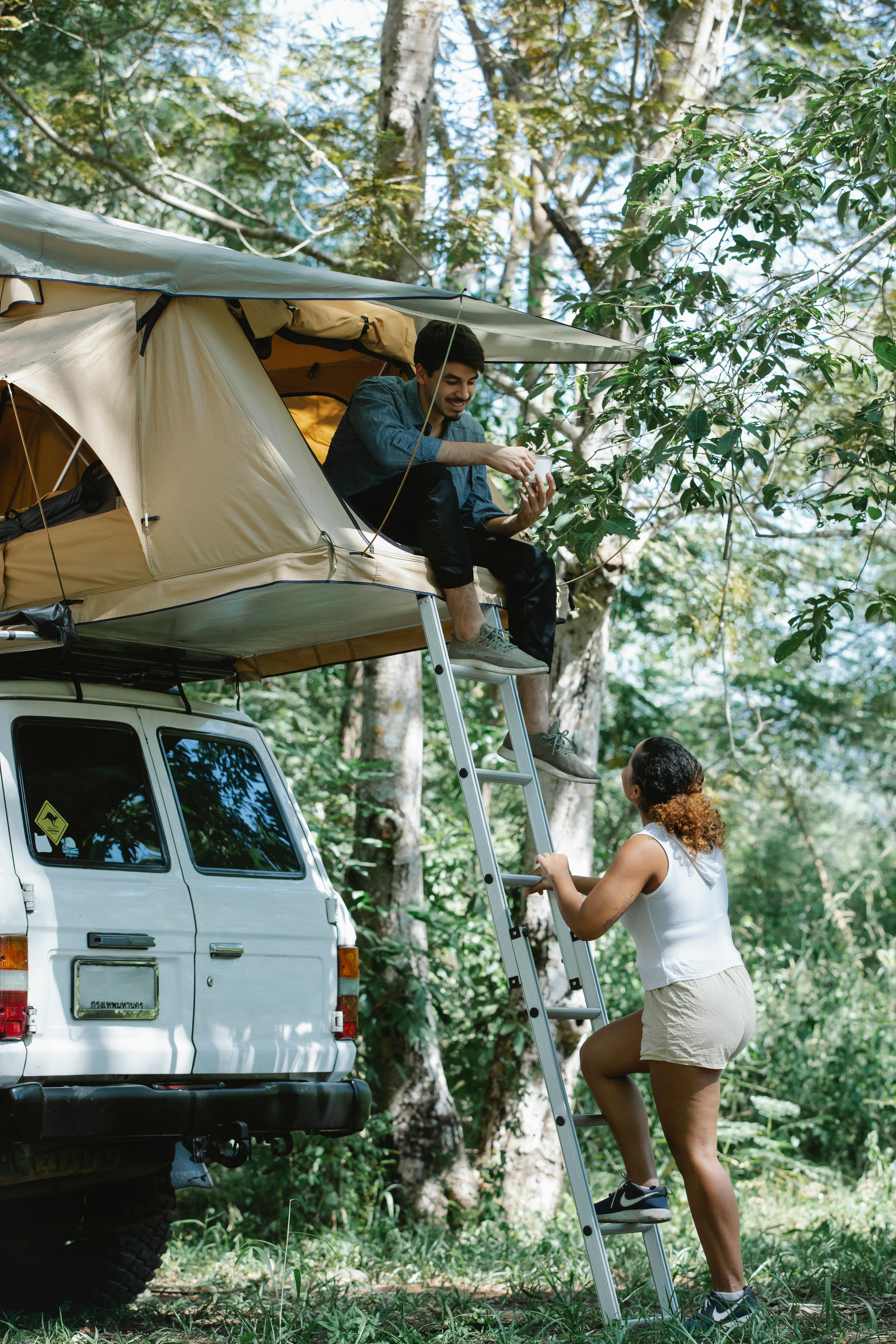 young romantic couple chatting at campsite in forest