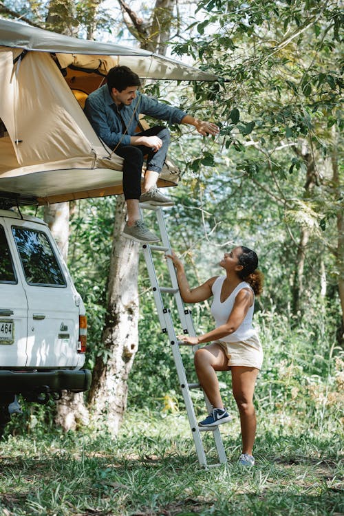 Young multiracial couple communicating during camping in nature