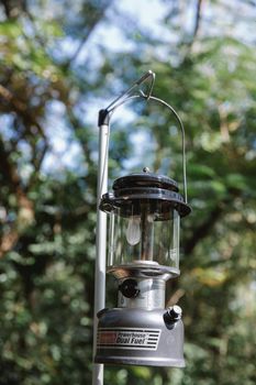 Vintage paraffin lamp hanging in woods during picnic