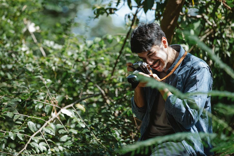 Content Man Taking Photos In Verdant Forest