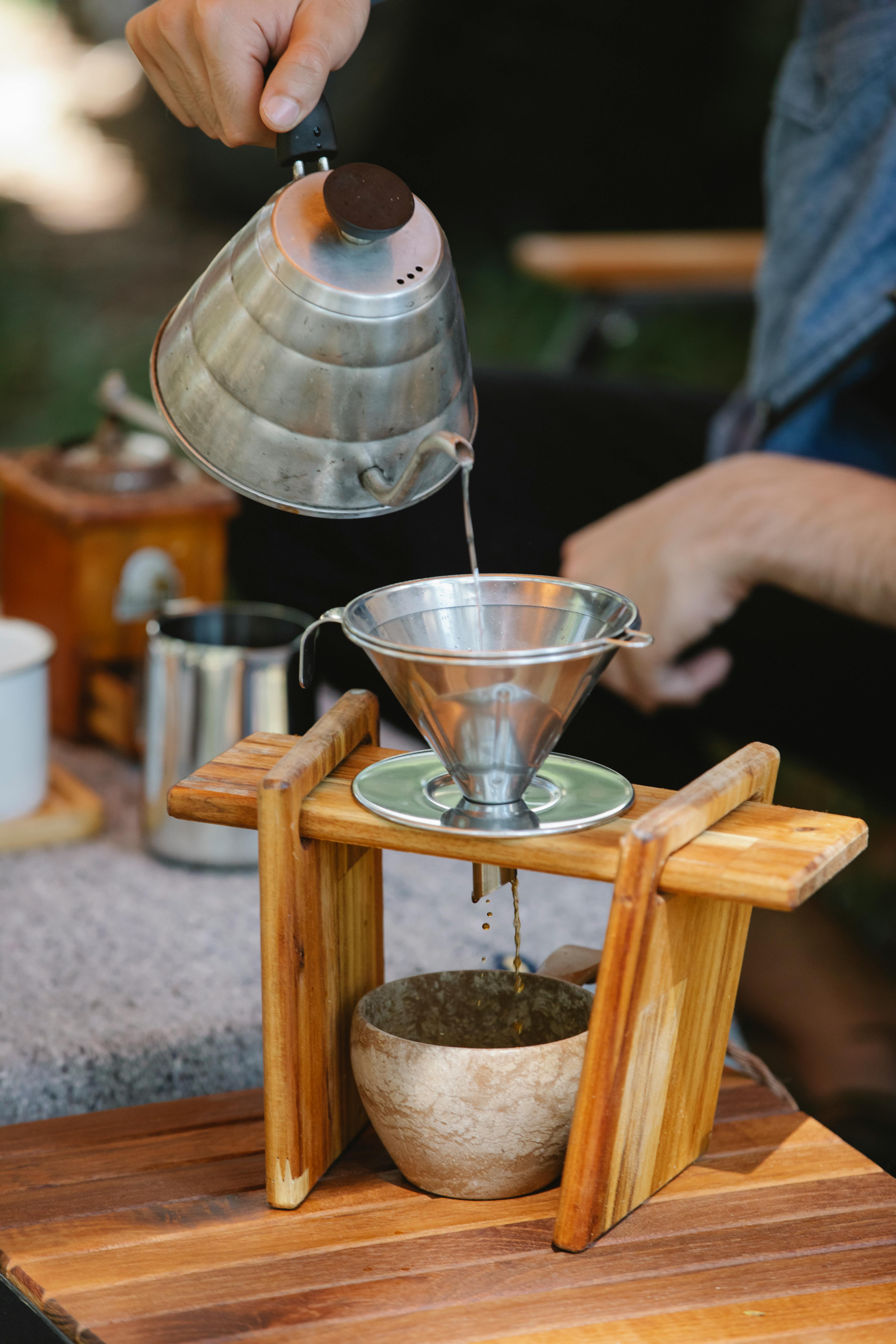 crop faceless man pouring hot water into pour over filter