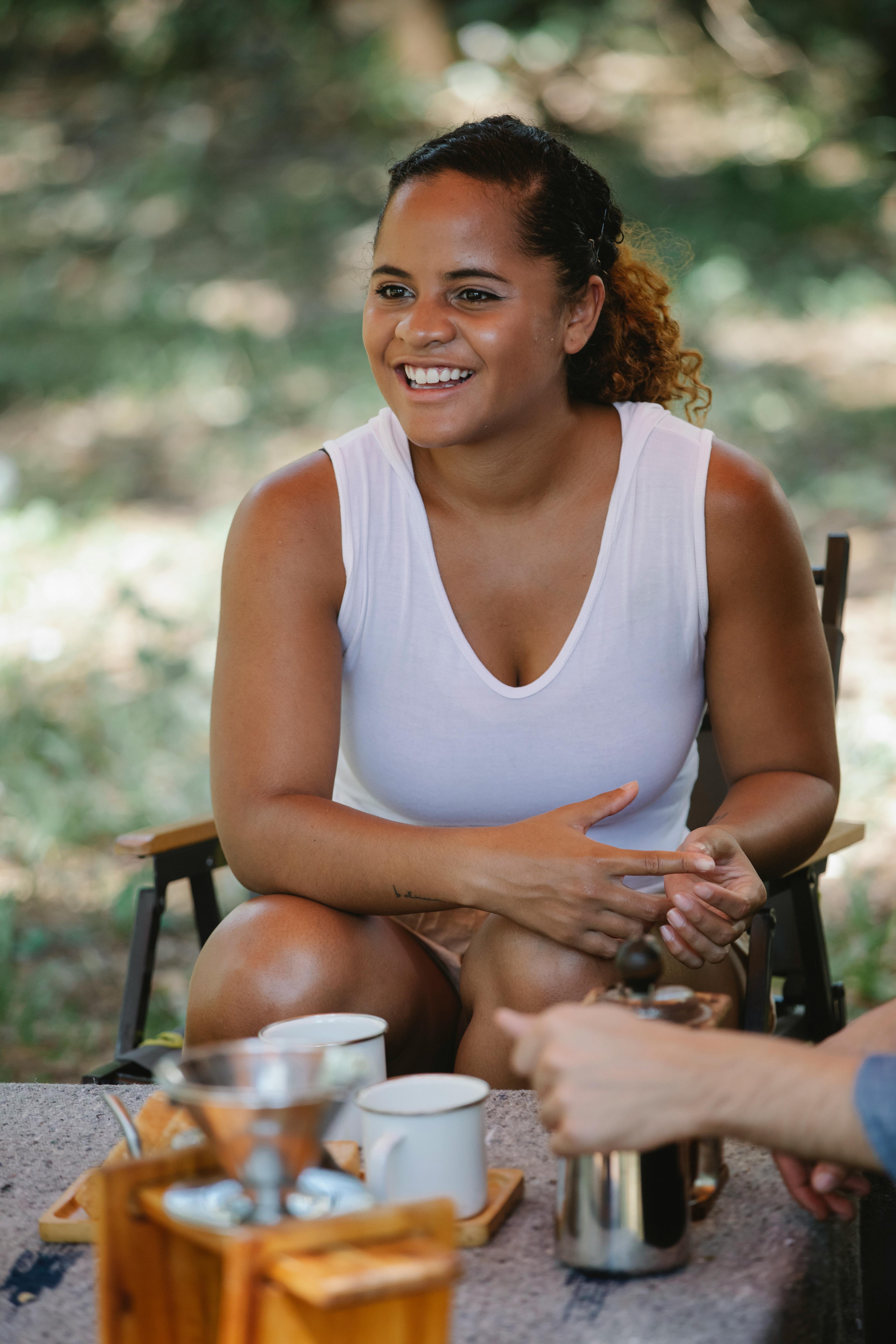 delighted young ethnic woman smiling during picnic