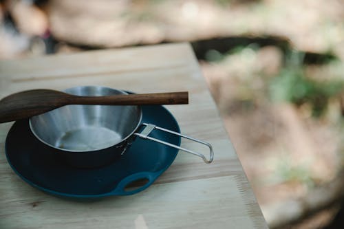 Marmite En Acier Argenté Sur Soucoupe En Céramique Bleue