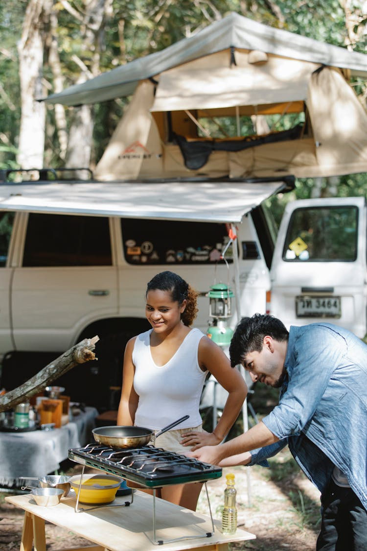 Content Diverse Couple Cooking In Camp