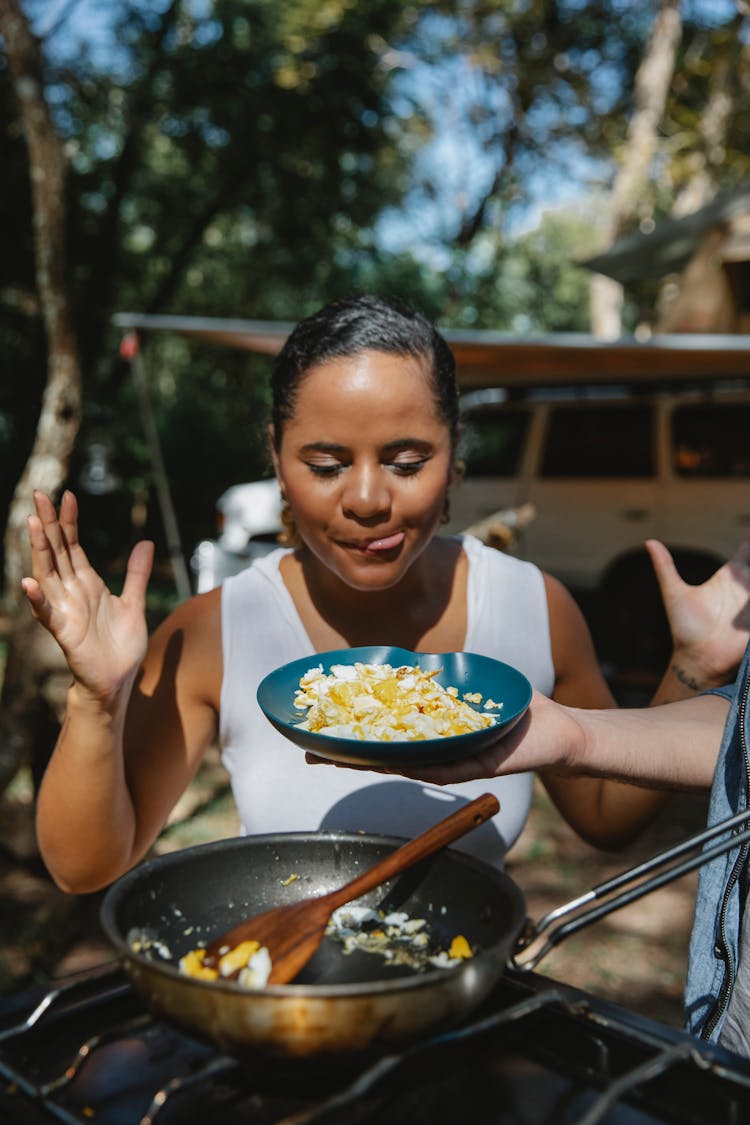 Positive Ethnic Woman Looking At Scrambled Eggs