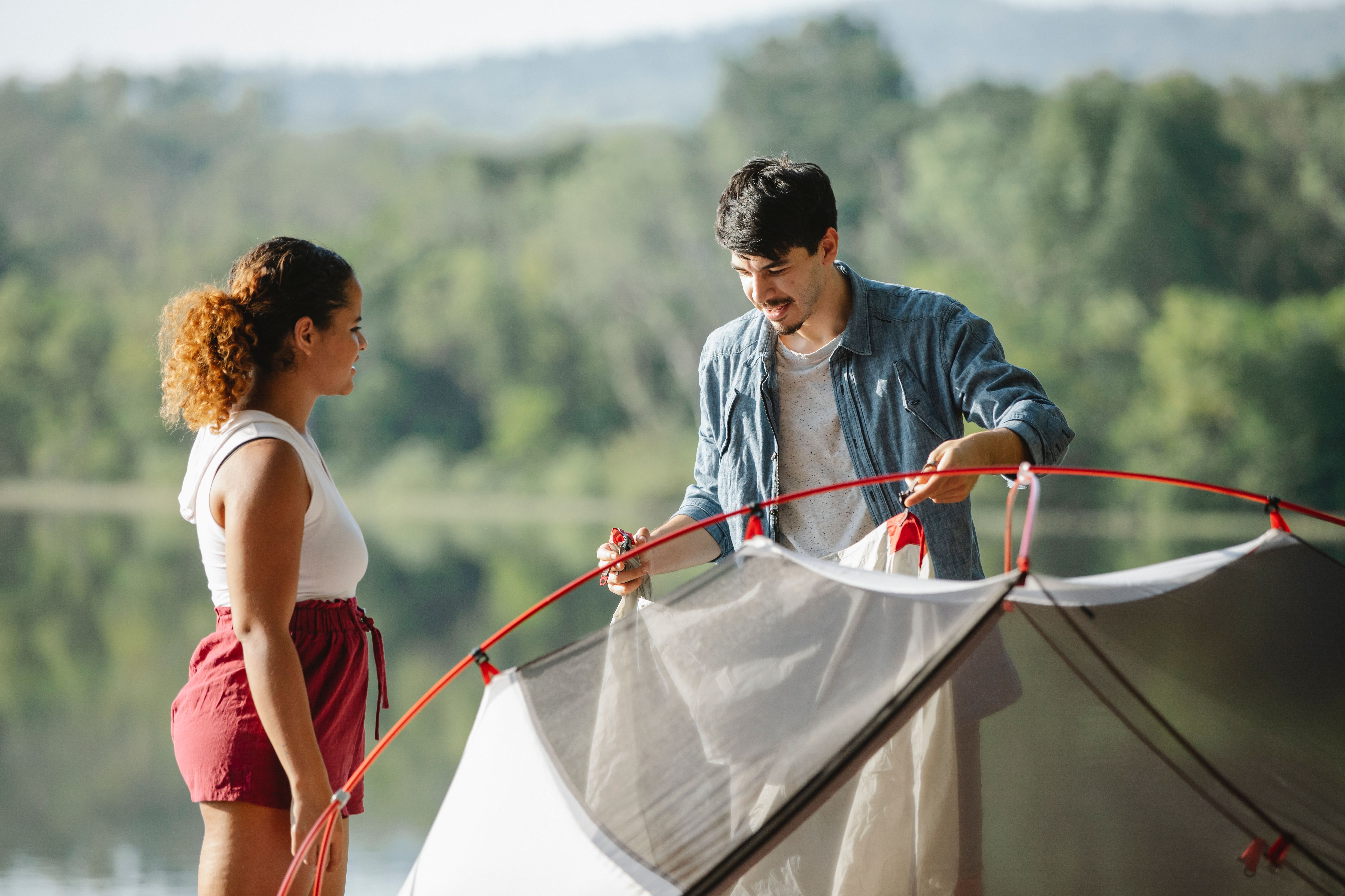 A couple smiling while easily installing a canvas bell tent protector, demonstrating simple setup - canvas tent protector