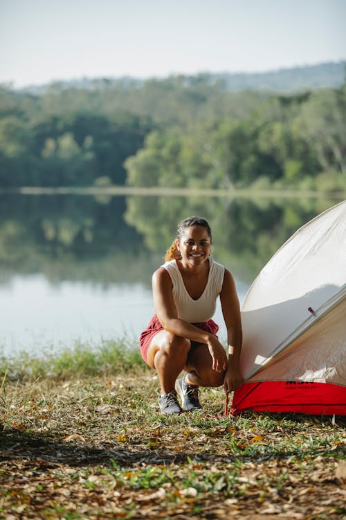 Vrouw In Witte Tanktop Zittend Op Rode En Witte Tent