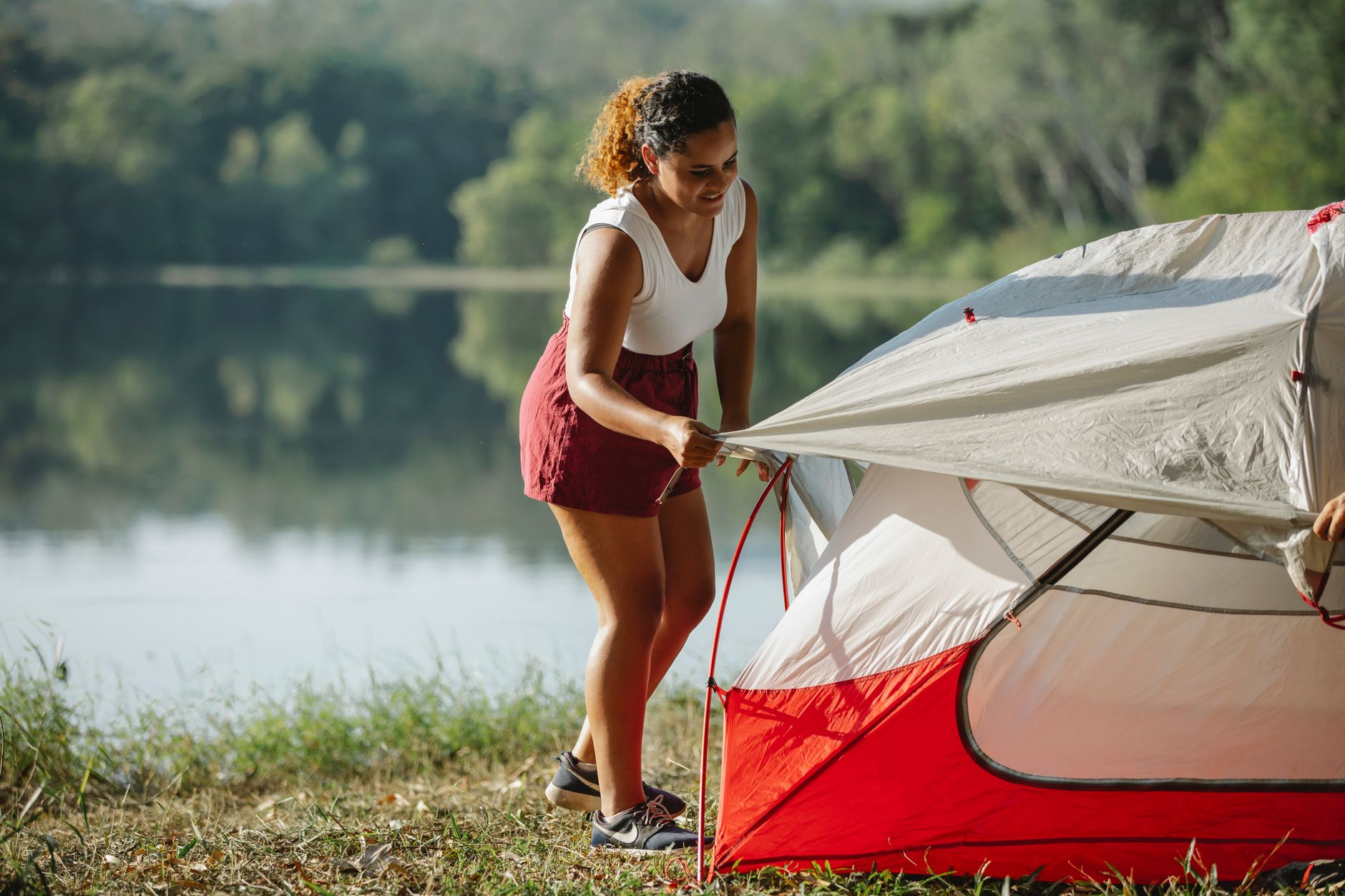 hiker setting up tent wilderness