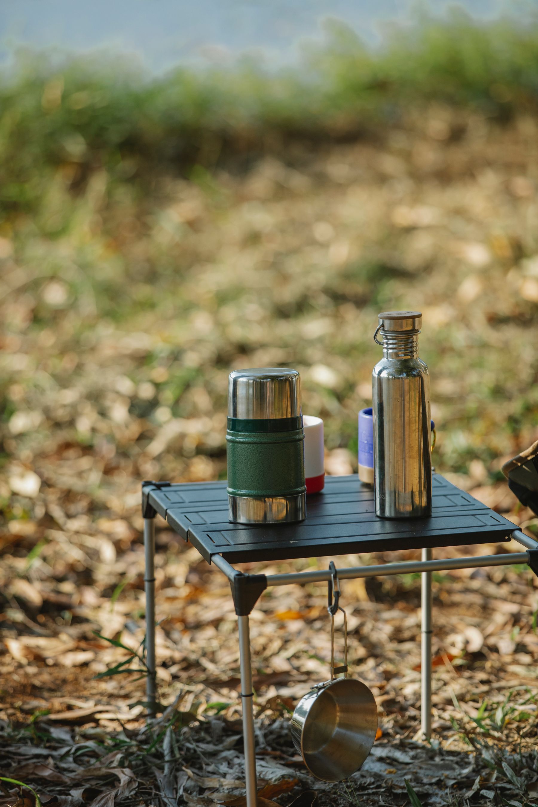 Organized folding camping table with outdoor drinkware and cooking equipment