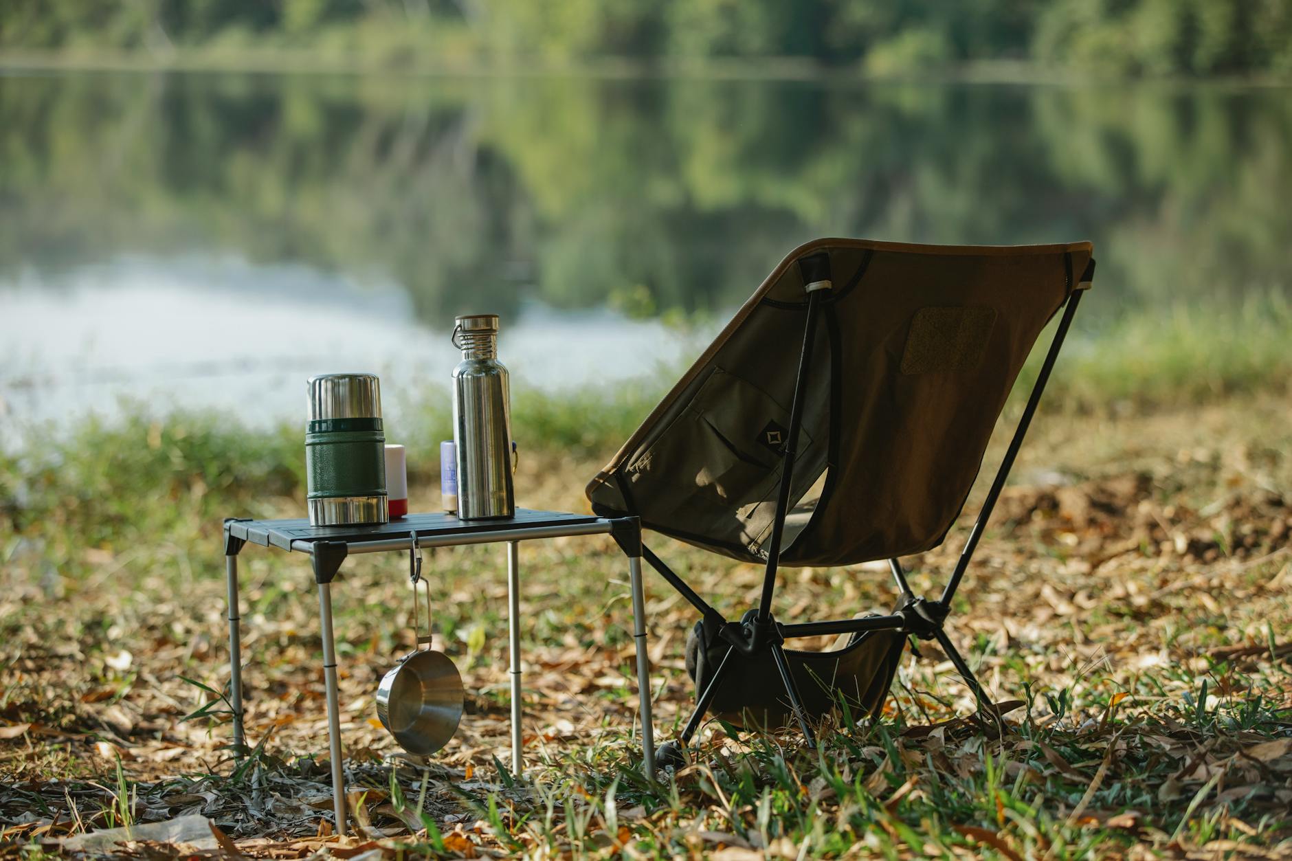 Camping chair near table on river shore