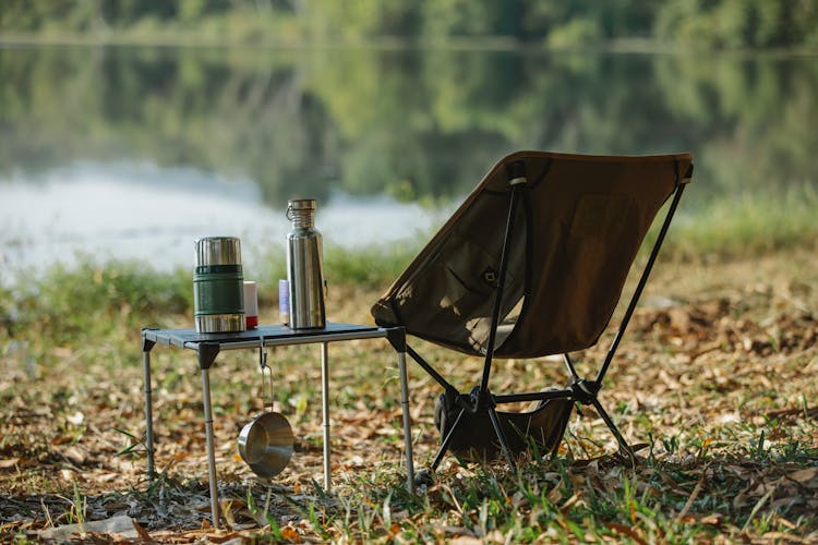 Camping Chair Near Table On River Shore